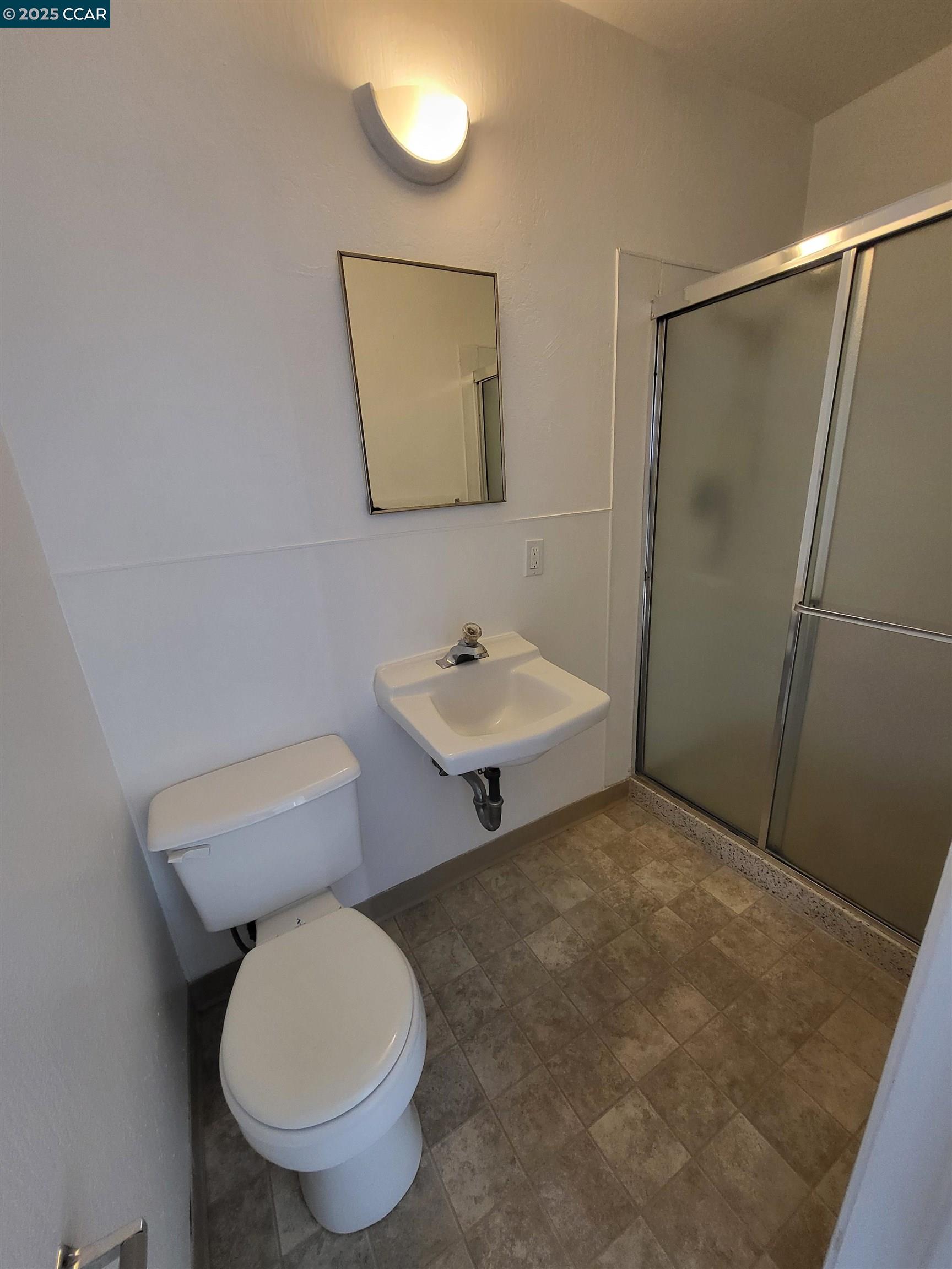 2488 Market Avenue, Unit 1 San Pablo, CA 94806 - Photo 4 of 4 a bathroom with a toilet a sink and mirror