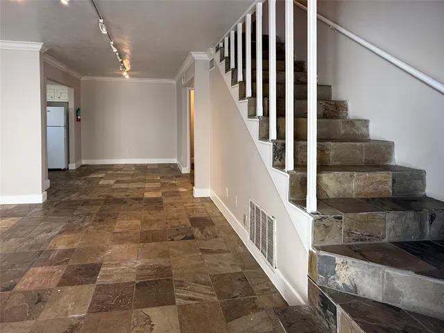 a view of staircase with lots of frames on wall and windows