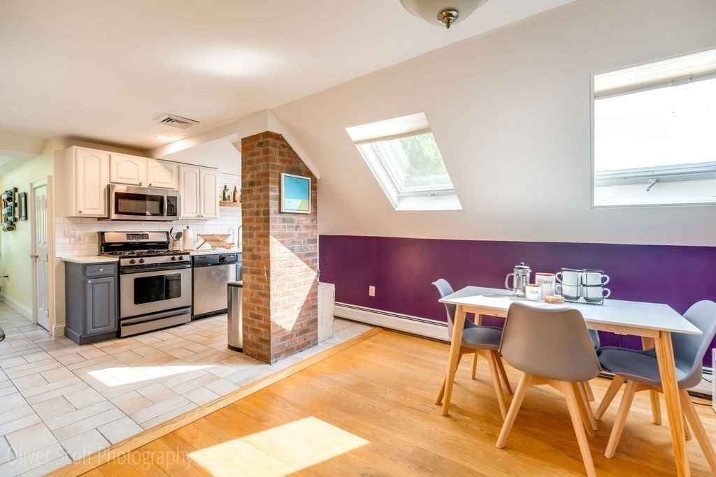 30 Graves Avenue, Unit B Northampton, MA 01060 - Photo 11 of 41 a kitchen with stainless steel appliances kitchen island granite countertop a refrigerator a stove a microwave oven with a dining table and chairs