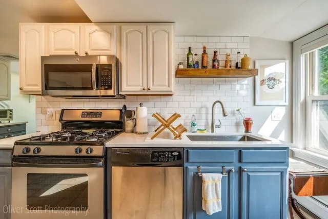 a kitchen with stainless steel appliances a stove a microwave and sink