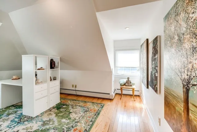 a view of a bedroom with wooden floor and front door