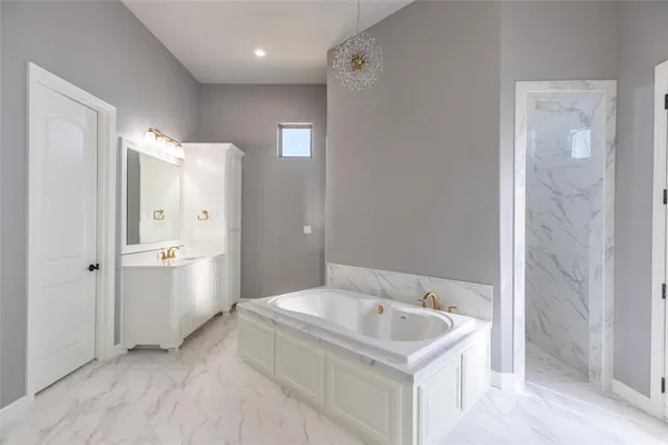 a bathroom with a tub shower vanity and a sink