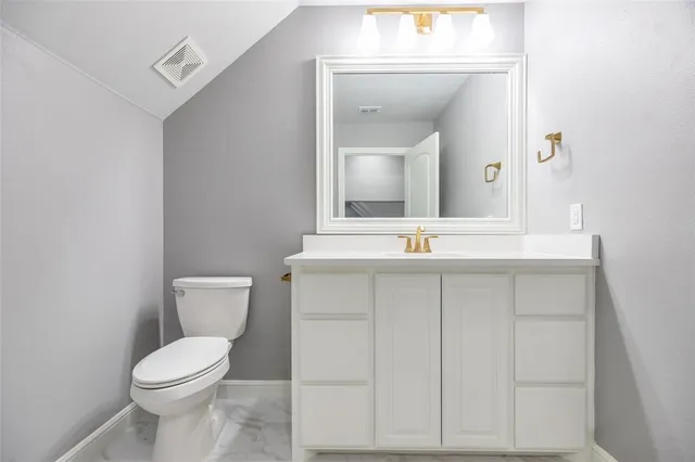 a bathroom with a toilet a sink and mirror