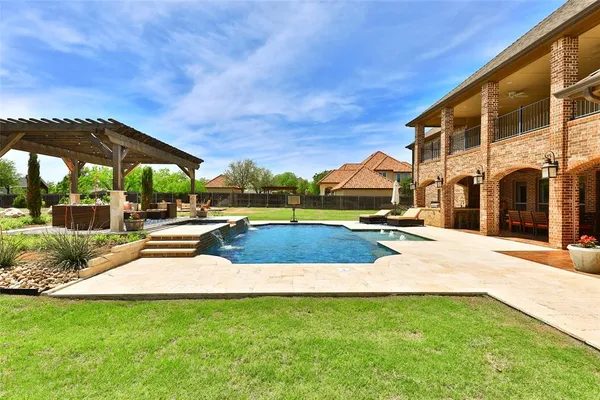 a view of swimming pool with lawn chairs under an umbrella