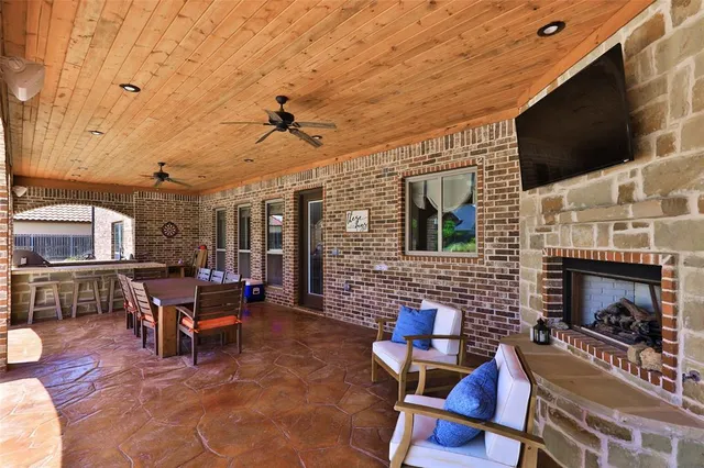 a living room with patio fireplace and a flat screen tv