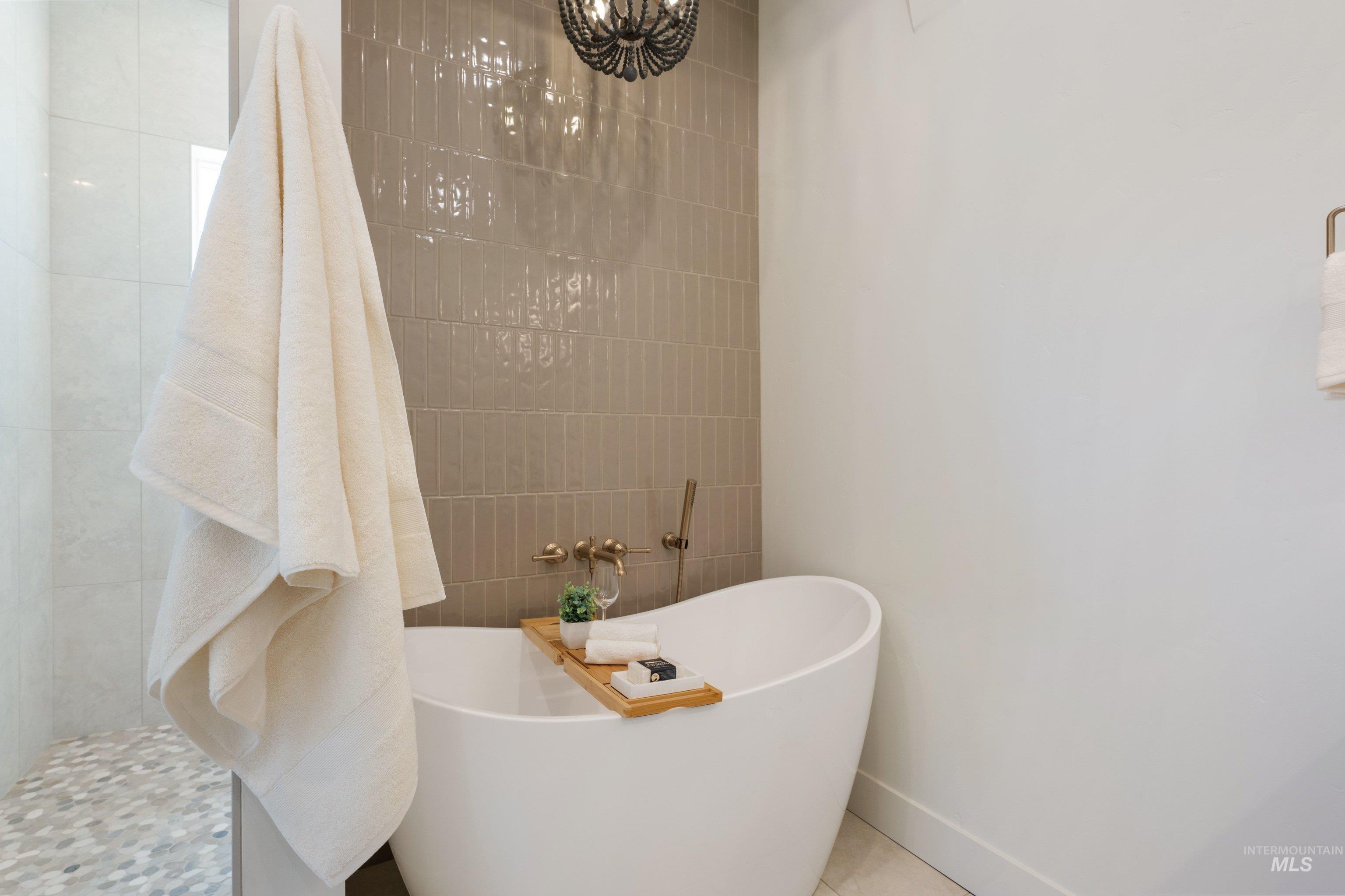 24763 Ardmore Court Caldwell, ID 83607 - Photo 33 of 50 Freestanding soaking tub with a wall-mounted brass faucet and handheld shower sprayer