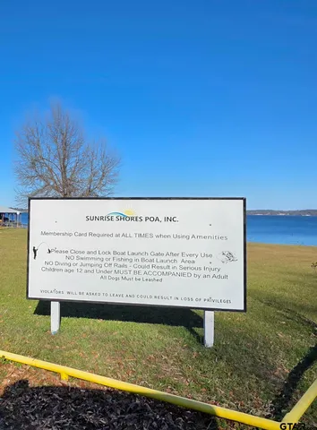 a view of a house with floor to ceiling windows and a small yard