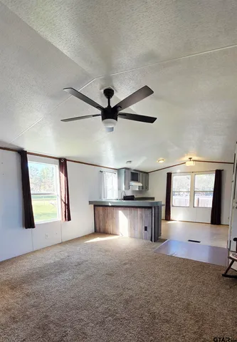 a view of a livingroom with a ceiling fan and window