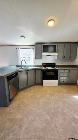 a large kitchen with stainless steel appliances granite countertop a stove and a sink