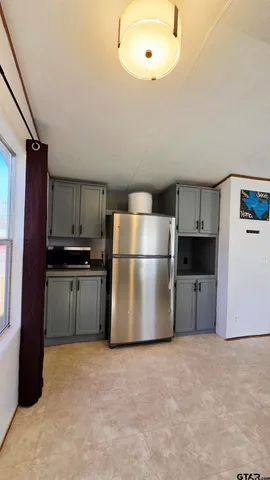 a kitchen with a refrigerator and a stove top oven