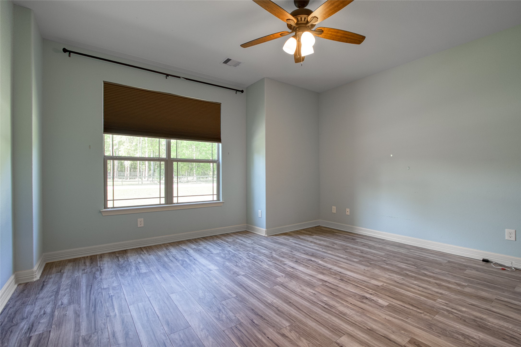 27684 Rio Blanco Drive Splendora, TX 77372 - Photo 18 of 31 an empty room with wooden floor chandelier fan and windows
