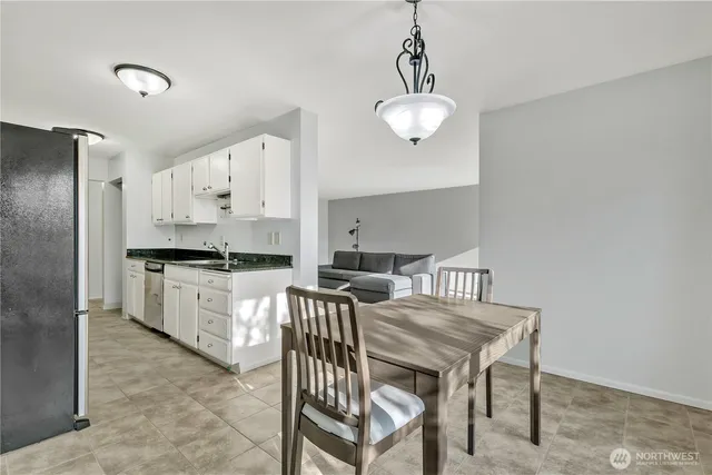 a kitchen with stainless steel appliances a table chairs and a refrigerator