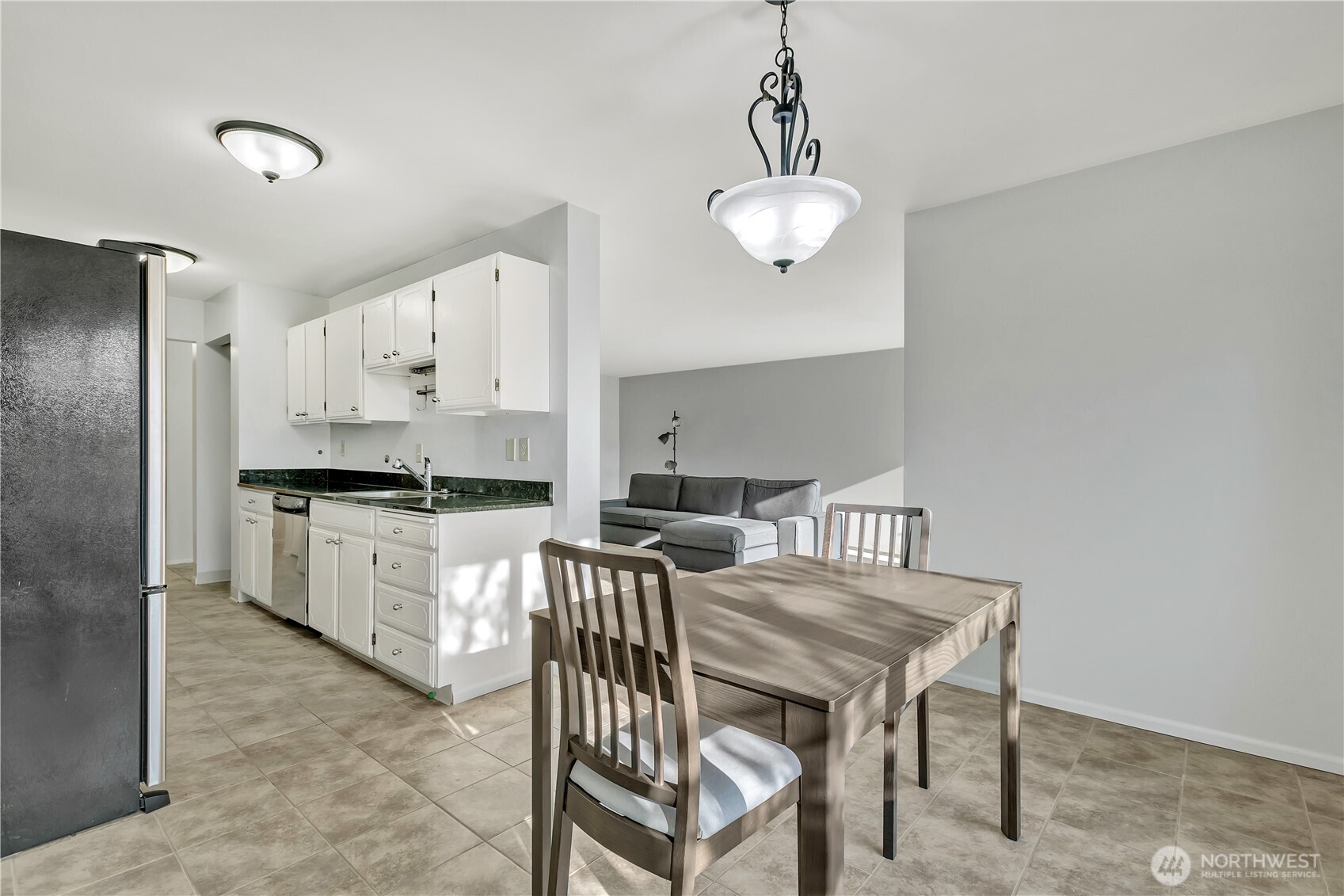 4545 Sand Point Way Northeast, Unit 207 Seattle, WA 98105 - Photo 11 of 25 a kitchen with stainless steel appliances a table chairs and a refrigerator