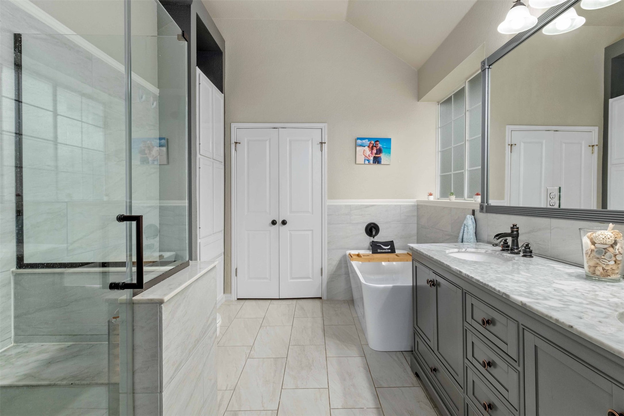 3704 Runnels Court Austin, TX 78732 - Photo 15 of 30 Bathroom with a shower stall, vanity, lofted ceiling, tile walls, and a freestanding bath