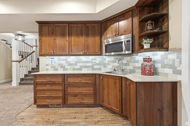 672 Perry Hollow Drive Mapleton, UT 84664 - Photo 76 of 106 Built-in wet bar featuring wood-finish cabinetry, stainless steel microwave, integrated sink, and white countertops