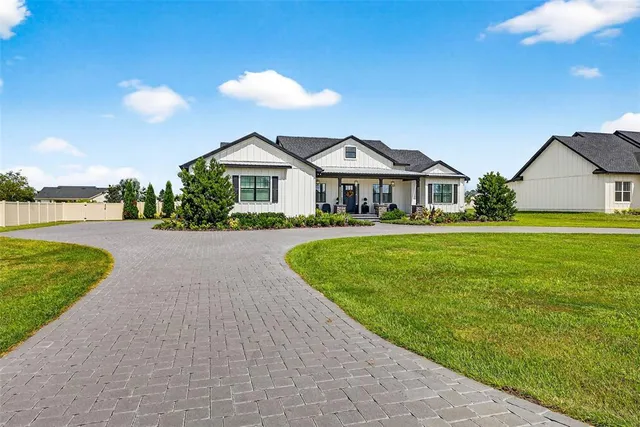 a front view of a house with a garden and lake view