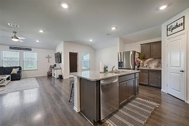 a kitchen with stainless steel appliances granite countertop a sink stove and refrigerator
