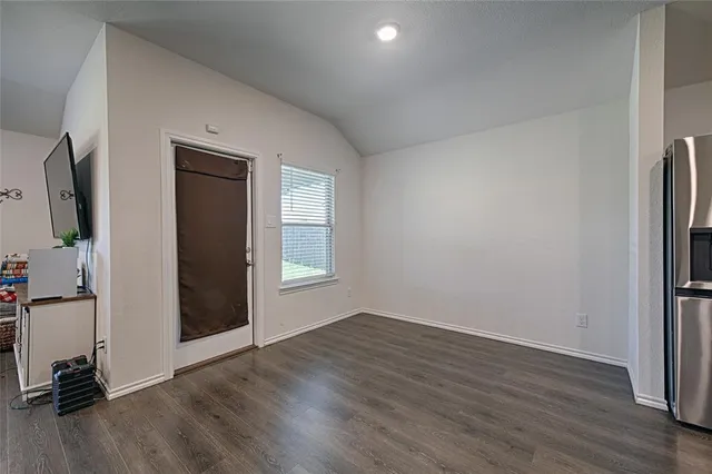 an empty room with wooden floor and a window