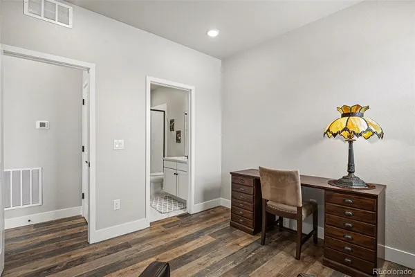 a view of a workspace with furniture and wooden floor
