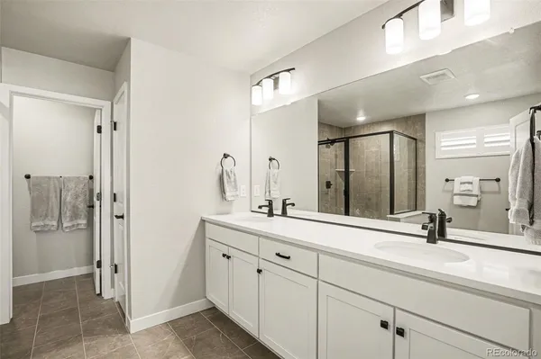 a bathroom with a double vanity sink mirror and next to a window