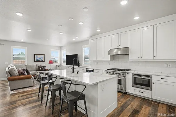 a kitchen with stainless steel appliances a stove a sink a refrigerator and a refrigerator