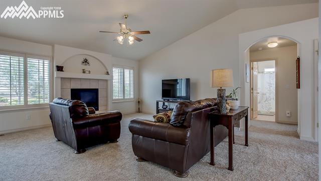 9232 Rockingham Drive Peyton, CO 80831 - Photo 6 of 35 Living room with ceiling fan, lots of space and cozy fireplace.