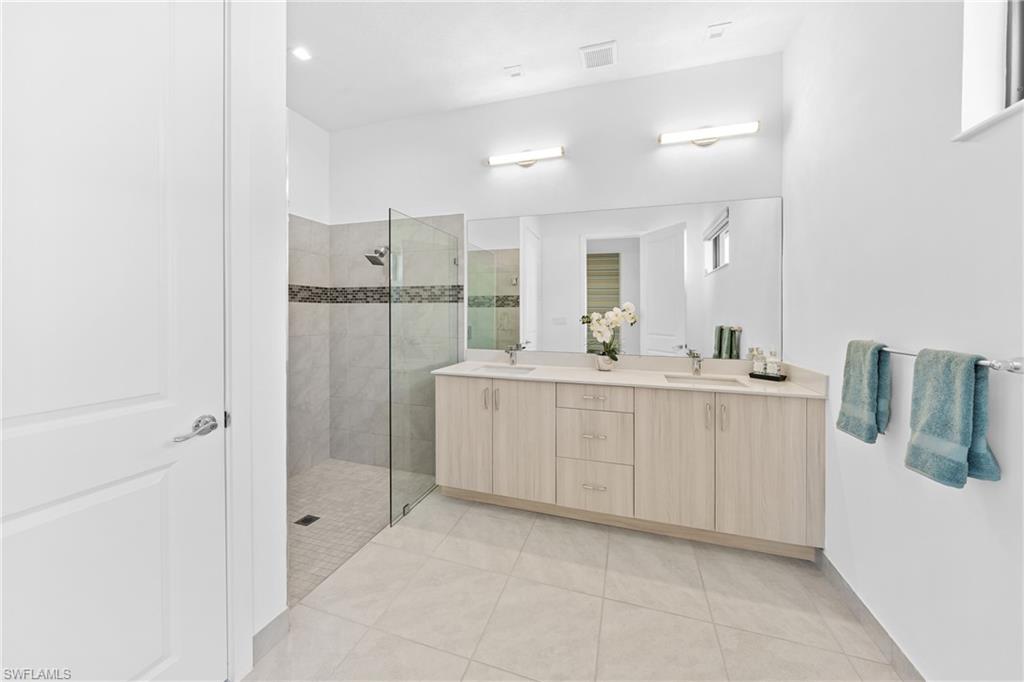 4947 Brigata Way Avenue Immokalee, FL 34142 - Photo 15 of 50 a bathroom with a double vanity sink mirror and shower