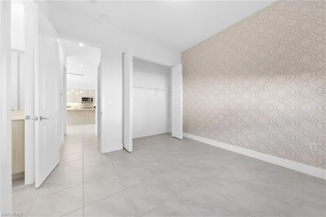 an empty room with white wall and shower