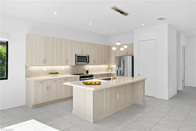 a kitchen with stainless steel appliances a stove a sink and a refrigerator