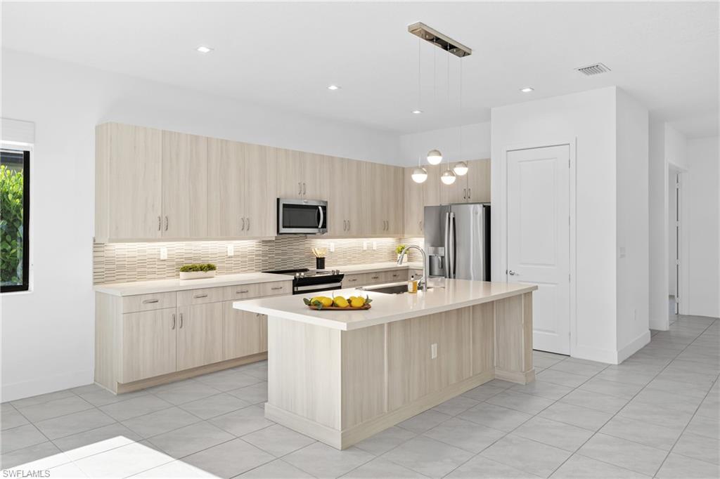 4947 Brigata Way Avenue Immokalee, FL 34142 - Photo 4 of 50 a kitchen with stainless steel appliances a stove a sink and a refrigerator