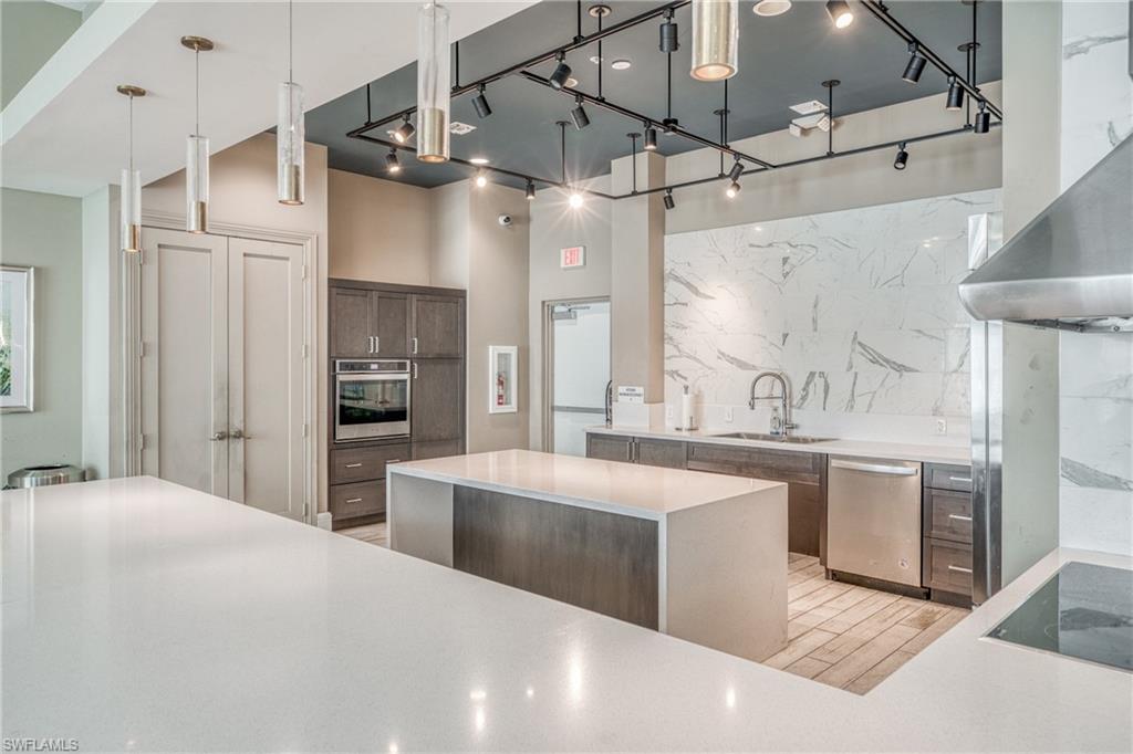 4947 Brigata Way Avenue Immokalee, FL 34142 - Photo 48 of 50 a large kitchen with cabinets a sink stainless steel appliances and a chandelier