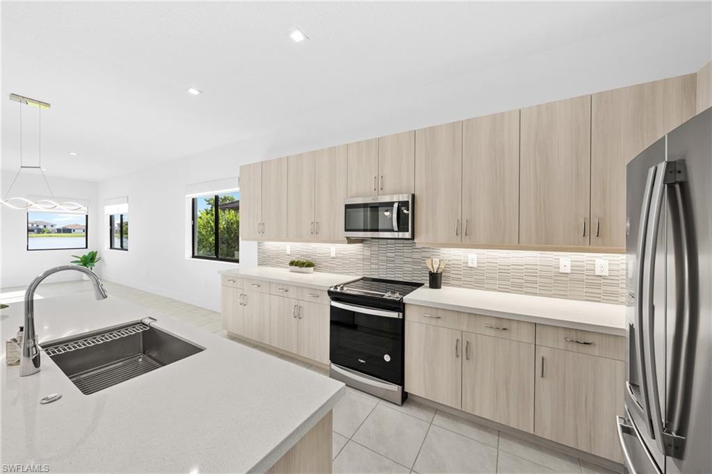 4947 Brigata Way Avenue Immokalee, FL 34142 - Photo 7 of 50 a kitchen with white cabinets and appliances