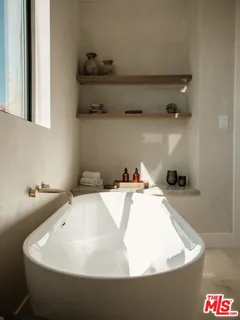 a view of a hallway to a livingroom with furniture and windows
