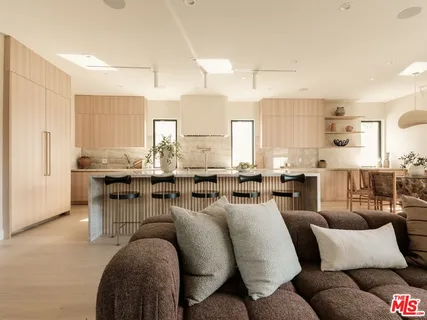 a living room with lots of white furniture and couches