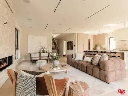 a living room with furniture a fireplace and a dining table with wooden floor