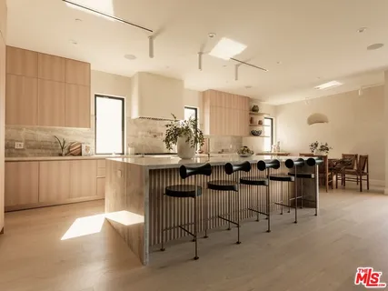 a large white kitchen with lots of counter top space and appliances