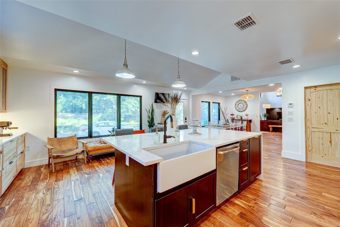 a large dining hall with stainless steel appliances granite countertop a stove and a wooden floors