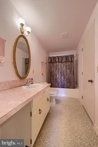 a bathroom with a granite countertop sink a mirror and a shower