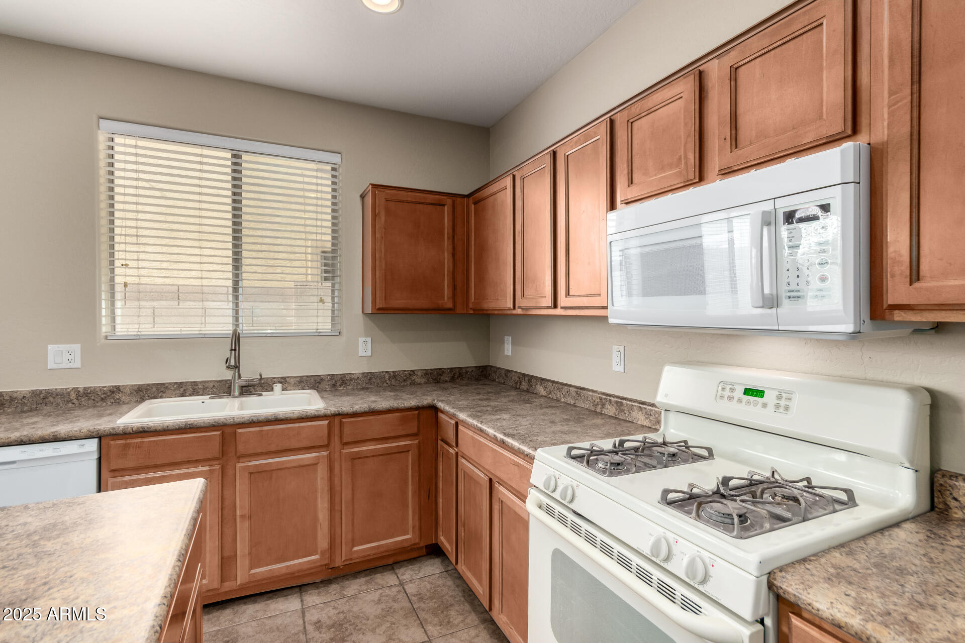 2203 West Vía Caballo Blanco Phoenix, AZ 85085 - Photo 11 of 28 a kitchen with granite countertop cabinets sink stove and window