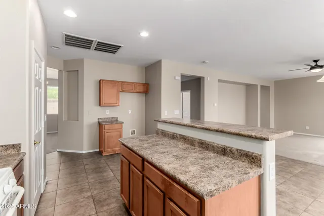 a view of kitchen island with stainless steel appliances granite countertop sink and refrigerator