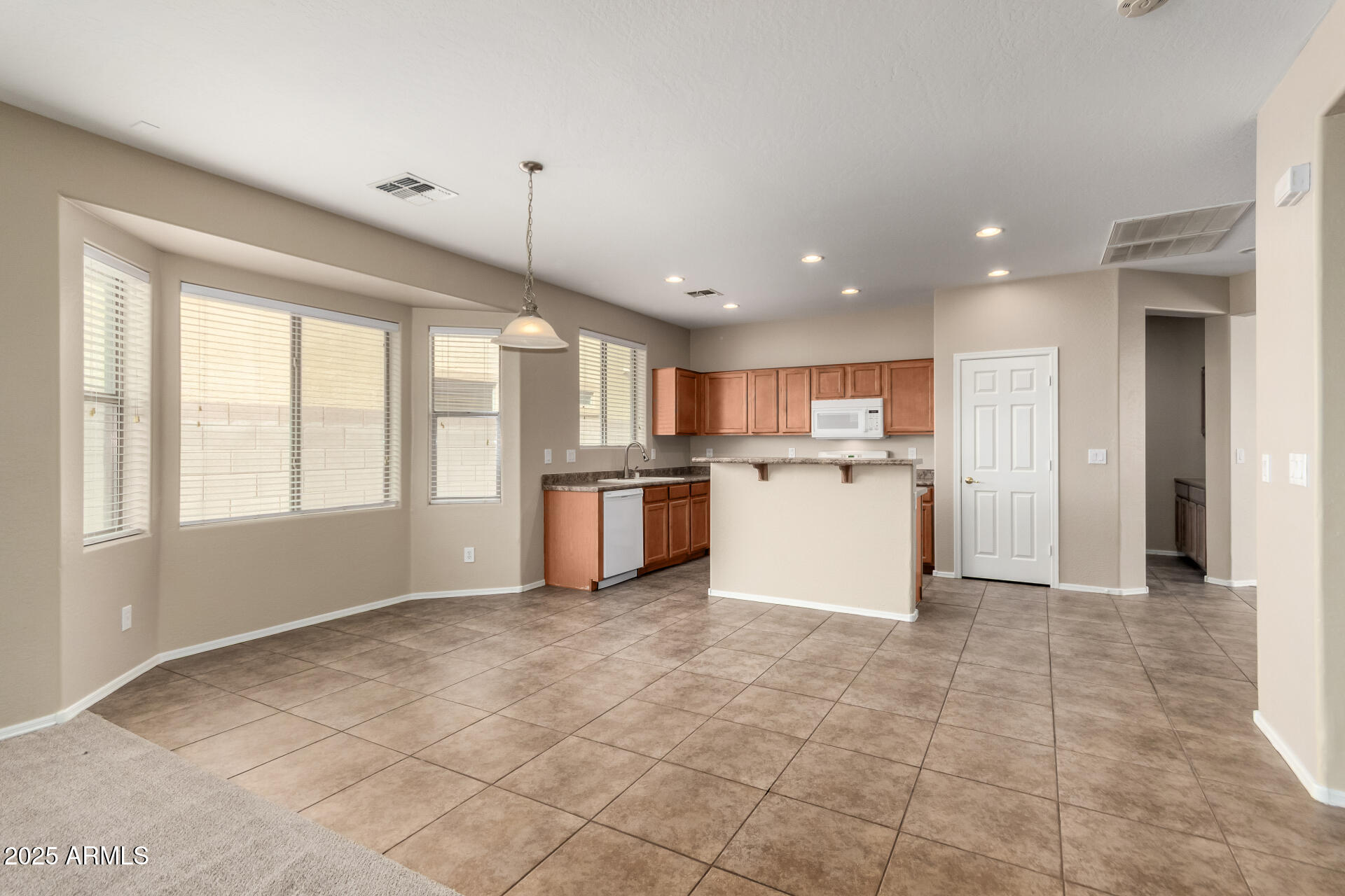2203 West Vía Caballo Blanco Phoenix, AZ 85085 - Photo 13 of 28 a view of a kitchen with kitchen island wooden floors stainless steel appliances windows