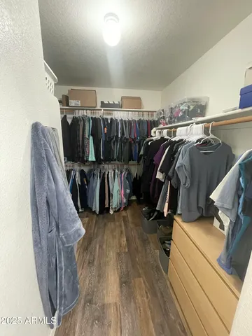a view of walk in closet with clothes and shoes