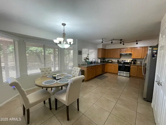 a kitchen with granite countertop stainless steel appliances a table and chairs in it