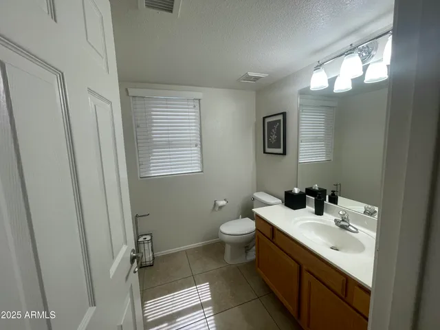 a bathroom with a double vanity sink toilet and a mirror