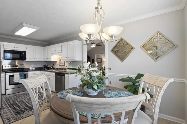 a dining room with wooden floor a chandelier a wooden table and chairs