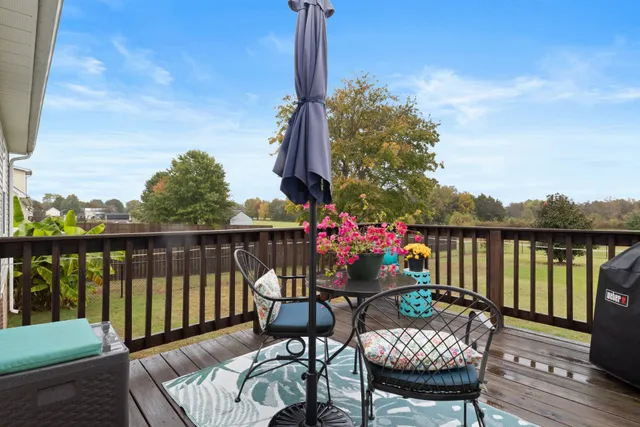 a balcony with wooden floor table and chairs