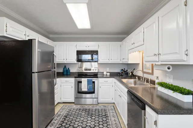 a kitchen with a sink a refrigerator a microwave and cabinets