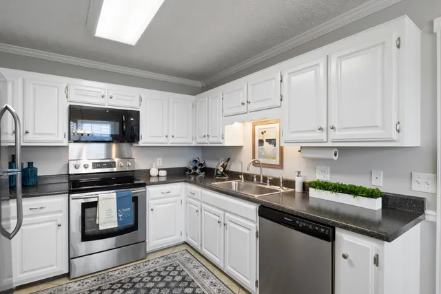 a kitchen with cabinets appliances a sink and a counter top space