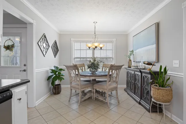 a dining room with furniture potted plants and a chandelier
