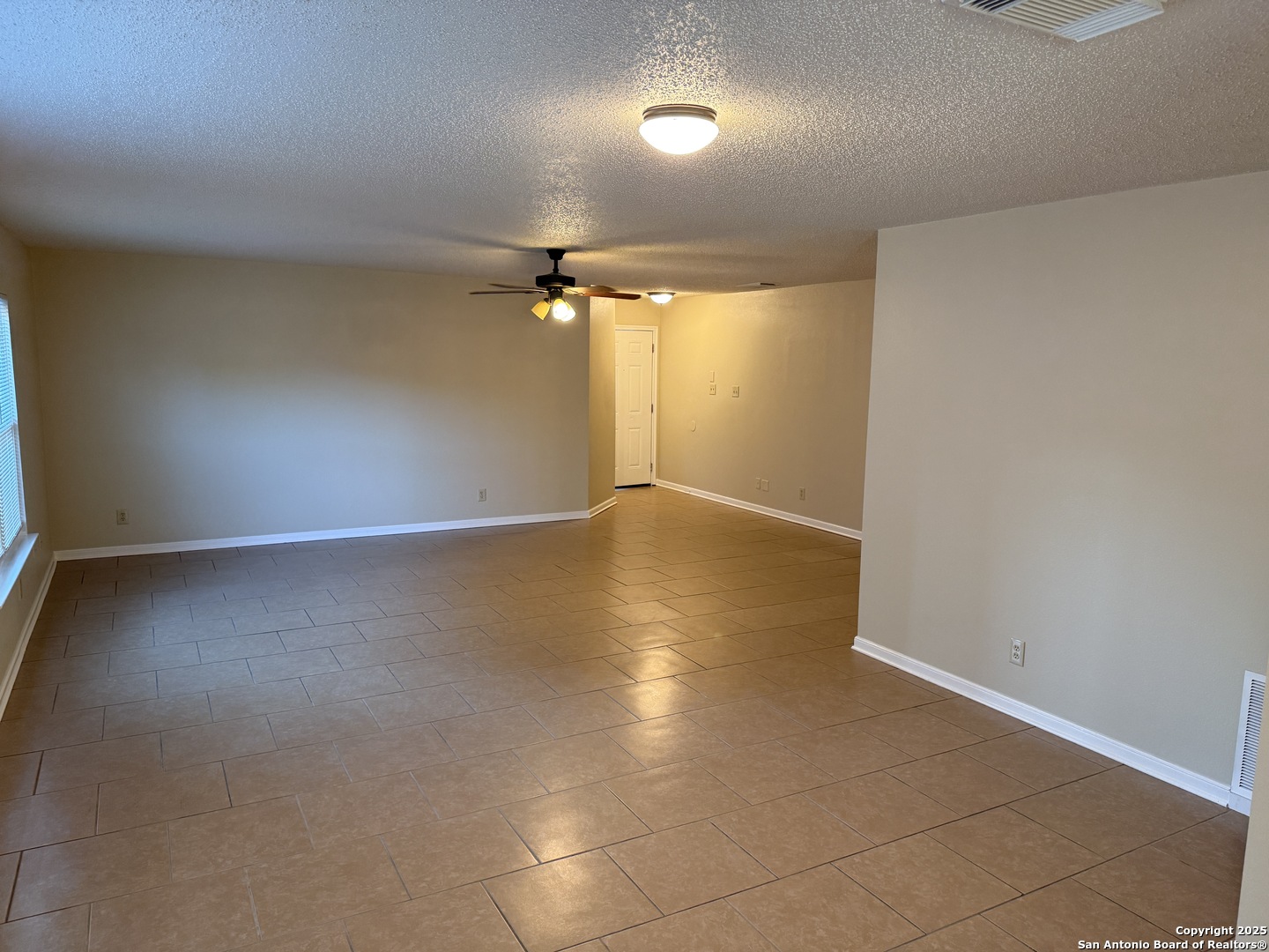 8015 Chestnut Gate Lane Converse, TX 78109 - Photo 5 of 21 an empty room with wooden floor and windows